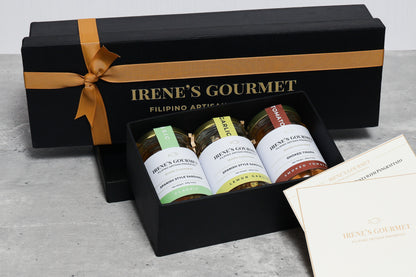 Gift box from Irene's Gourmet with jars of food and a card on a gray surface